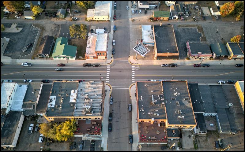 Looking down on the rooftops of several two story buildings on the main street of a small town.