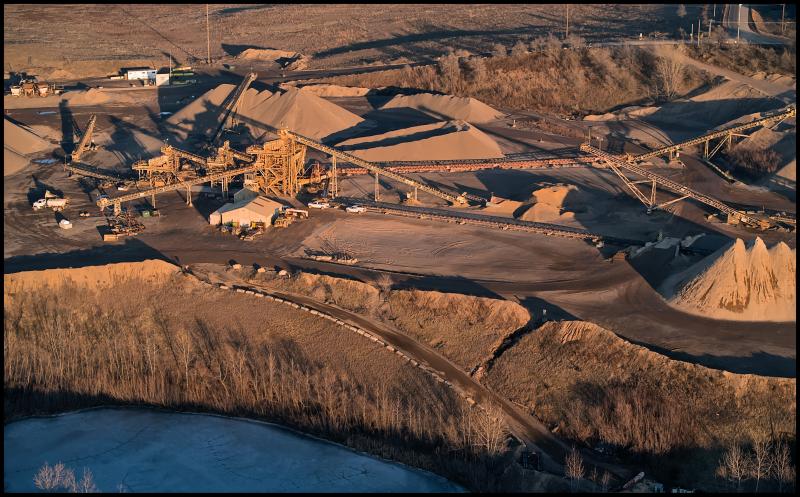 Aerial view of a sand and gravel quarry and some of the heavy equipment used to separate and sort it.