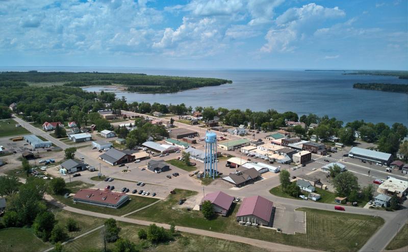 Aerial photo of the center of a small town on the shore of a very large lake. Photo shows about 6 blocks of downtown with blue water tower in the middle. 